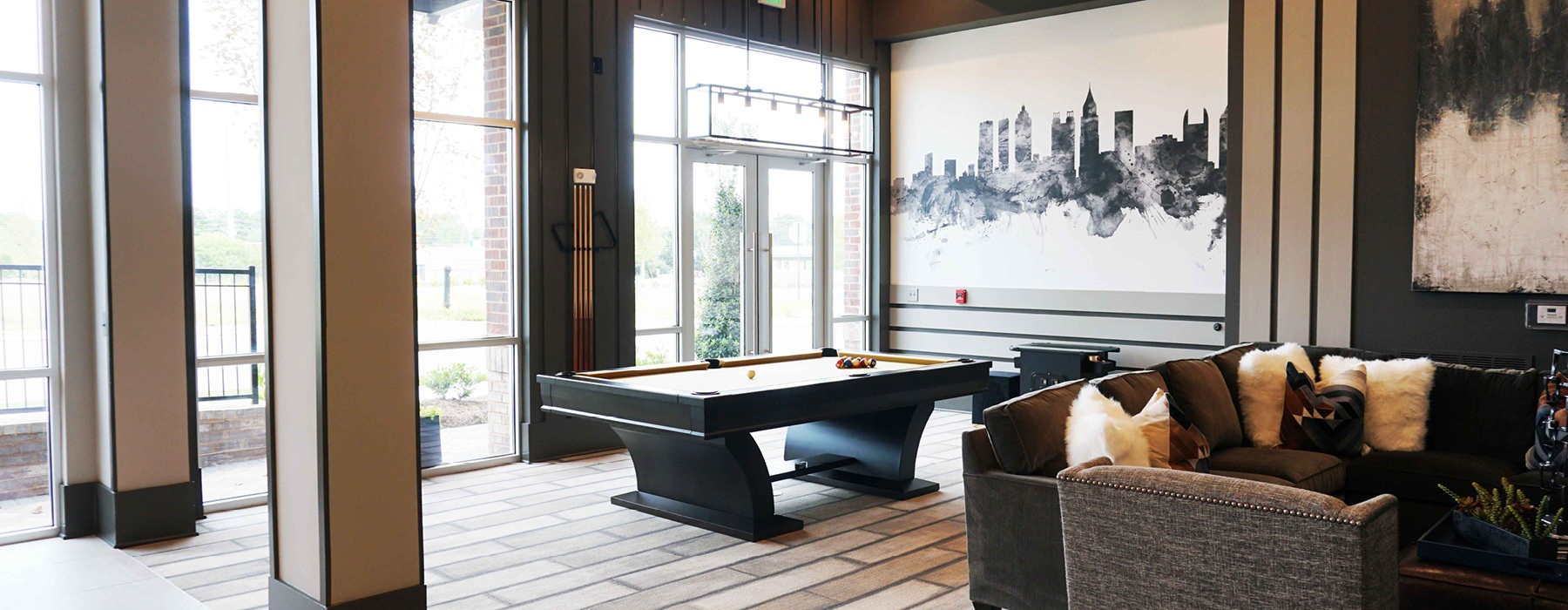 billiards table in large clubhouse with lots of natural lighting